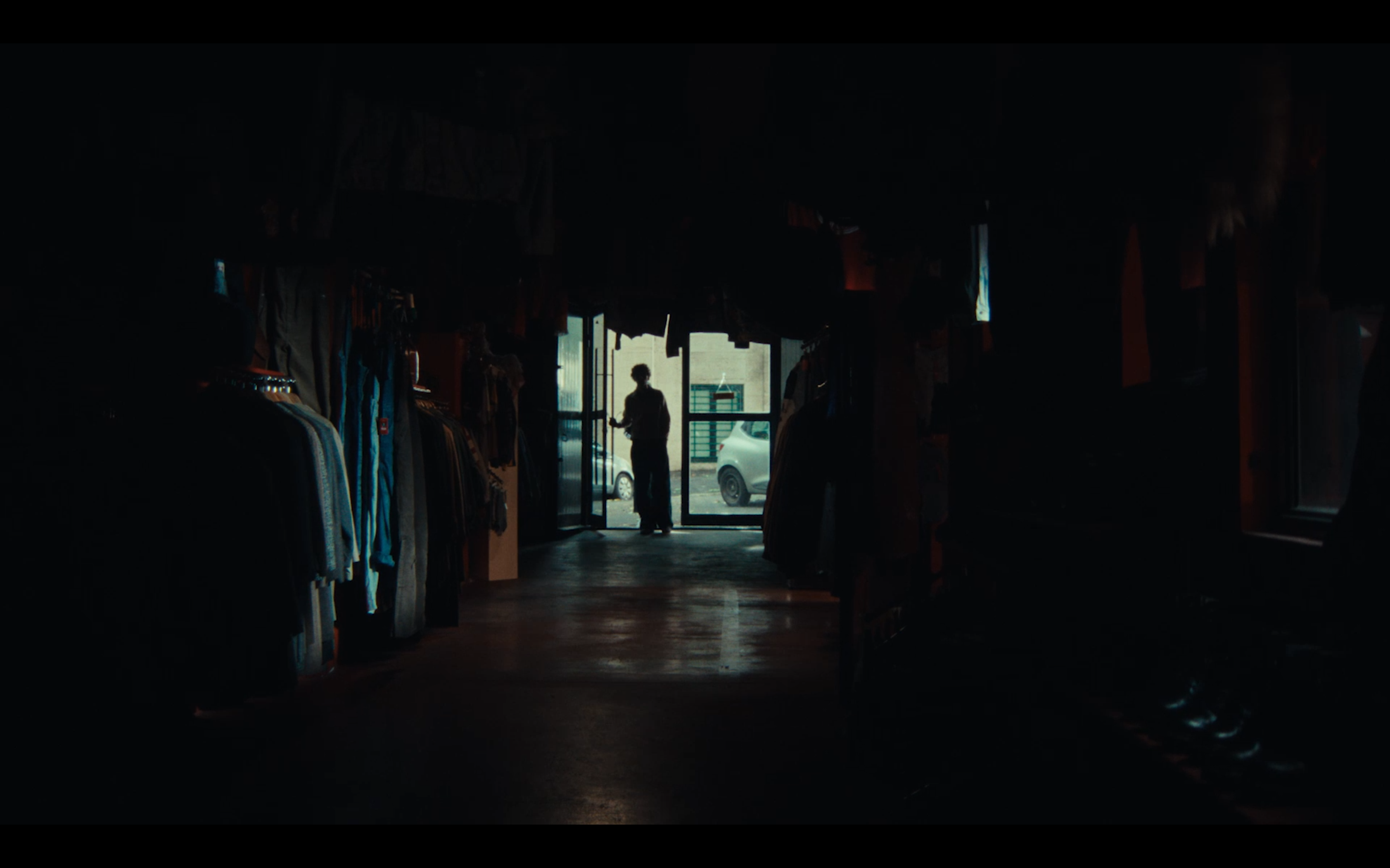 A backlit figure at the shop doorway