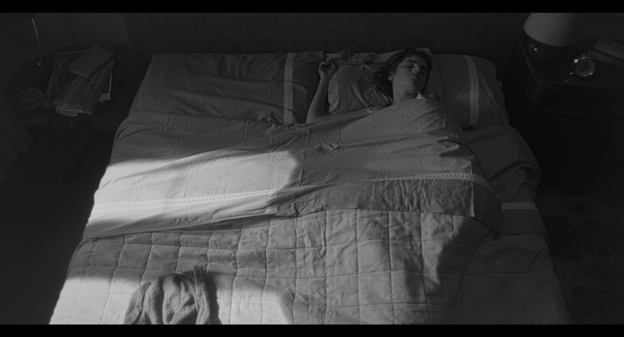 A woman asleep in a sunlit bedroom