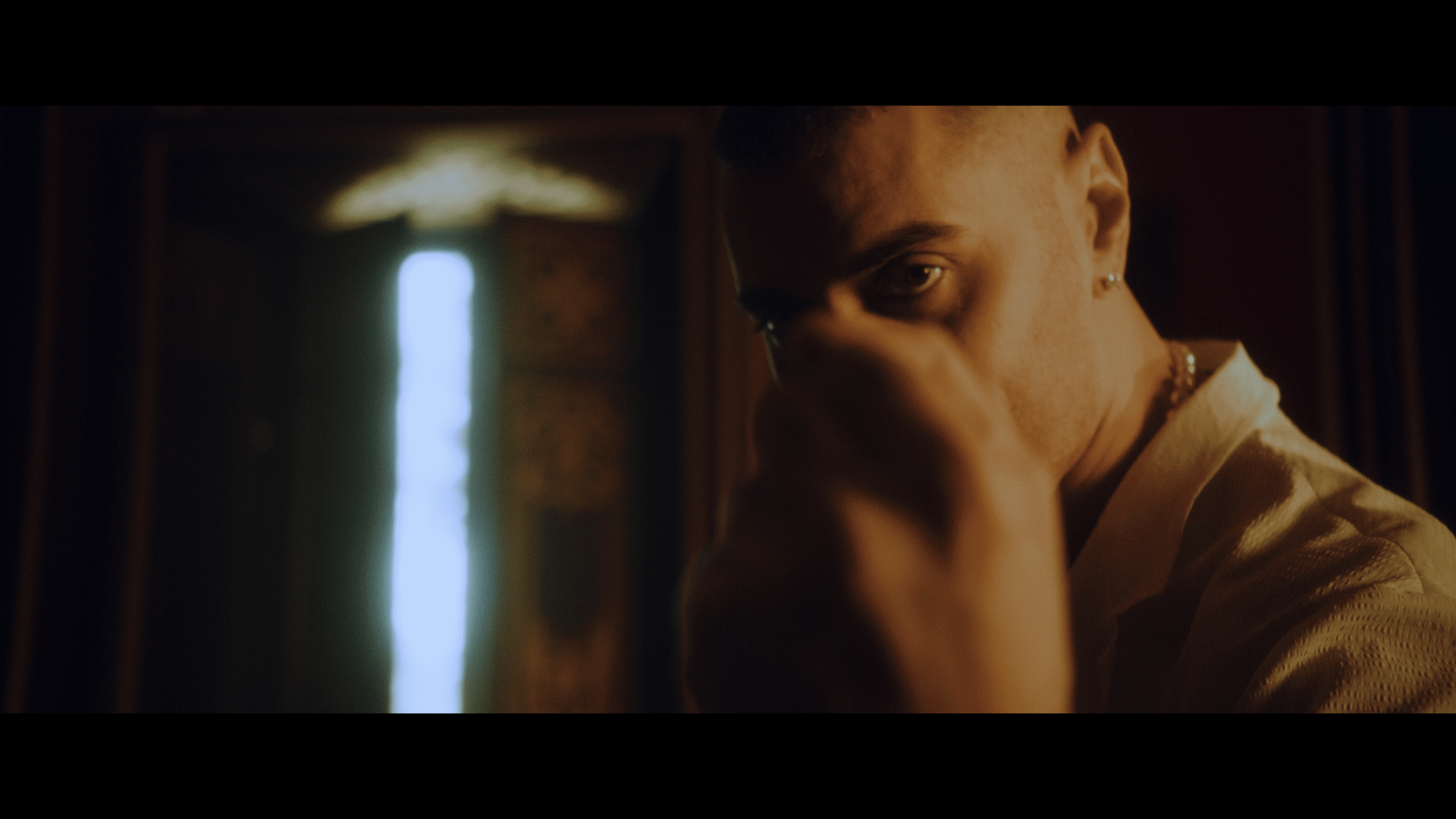 A close-up portrait of an artist in warm golden light