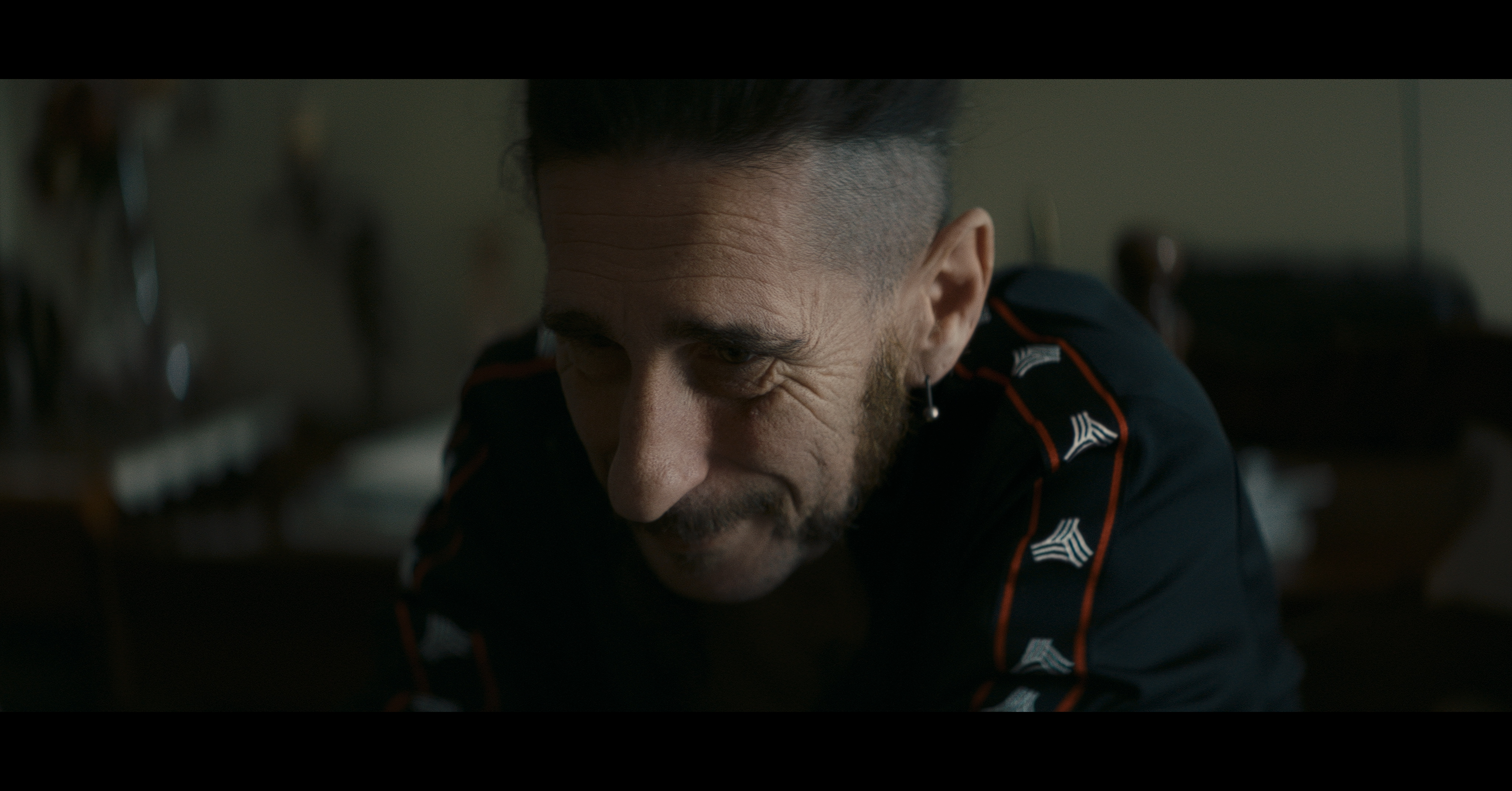 A close-up of a man looking down in soft light