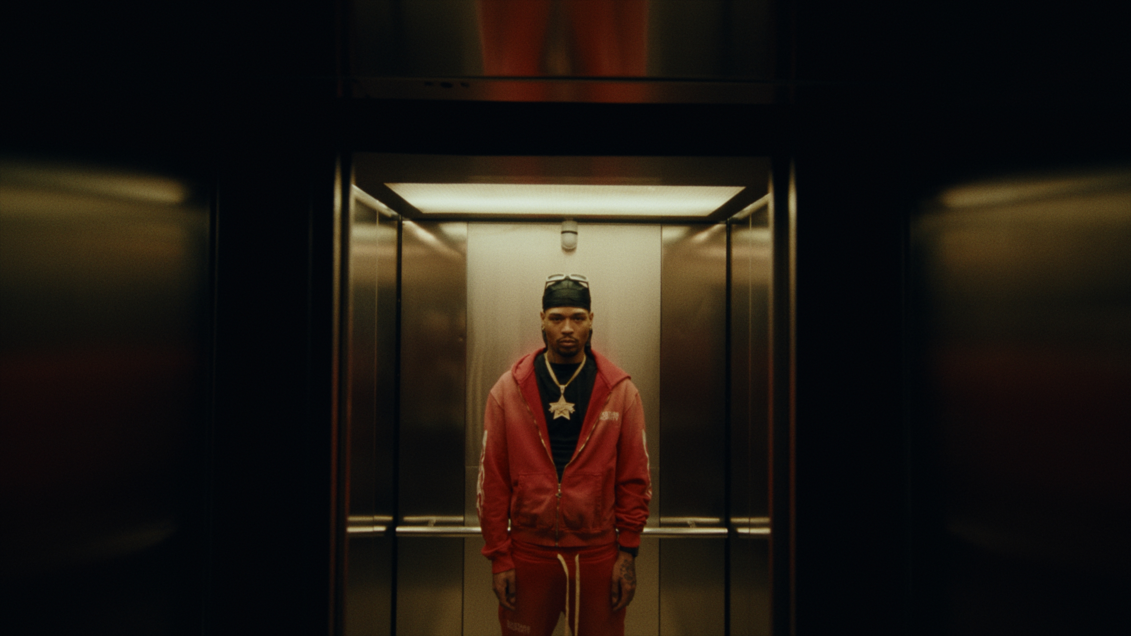An artist standing in a warmly lit elevator