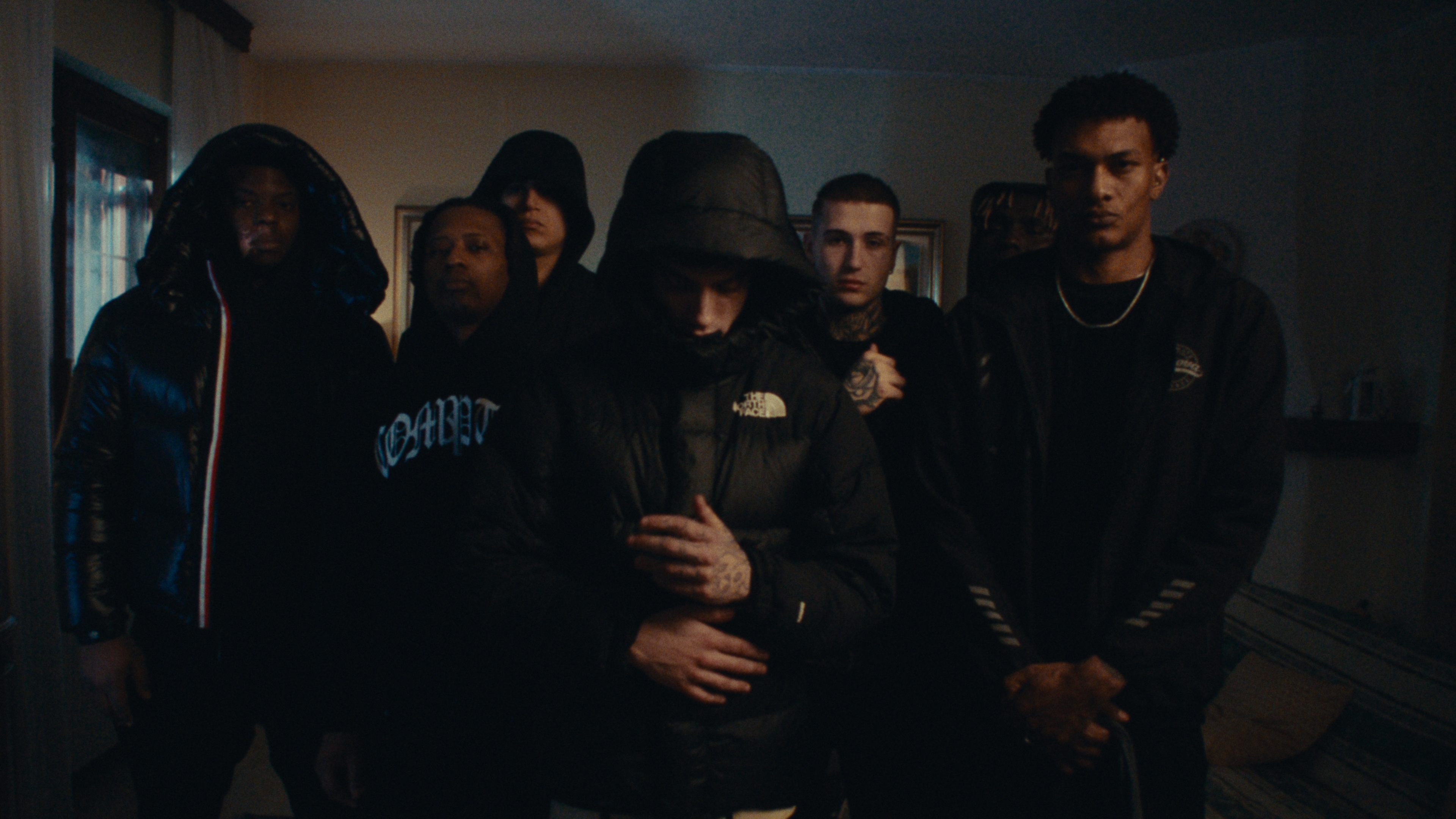 A group dressed in black in a dim room