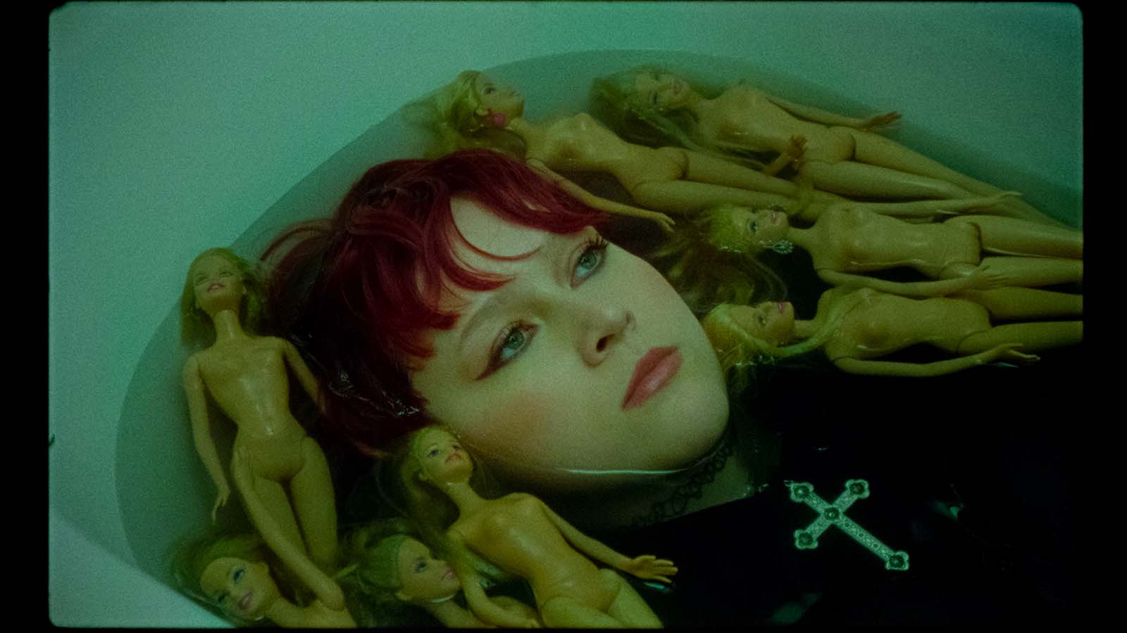 Karin Ann among dolls in green light
