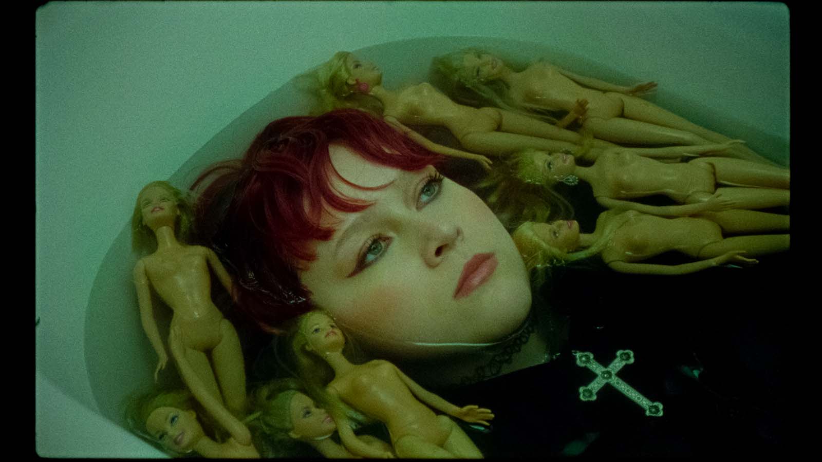 Karin Ann among dolls in green light