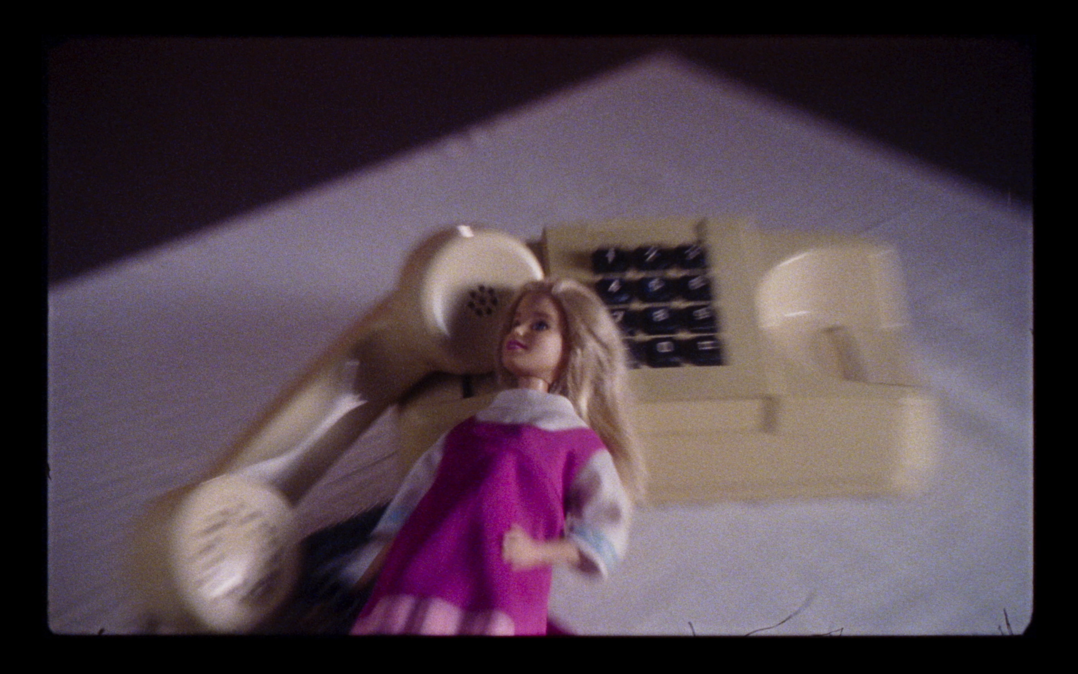 A doll beside a cream telephone