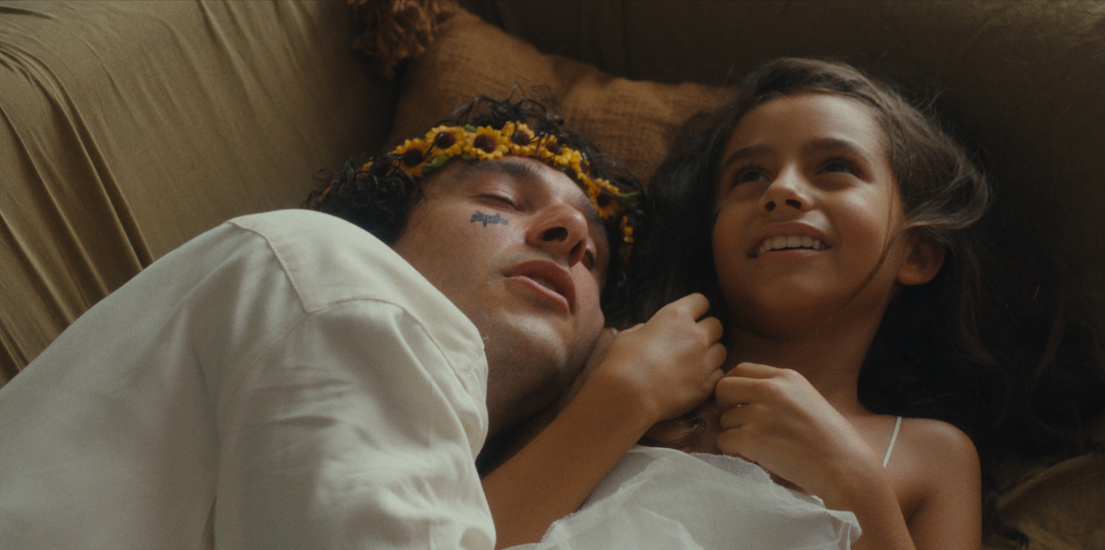 A child and an adult lying together on a bed