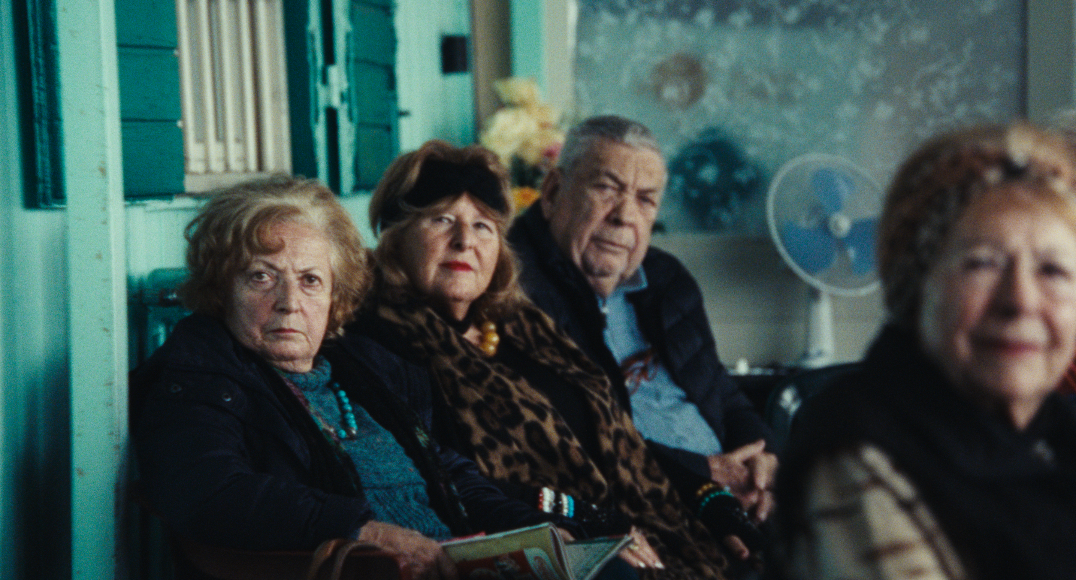 Three people seated beside the windows in blue light