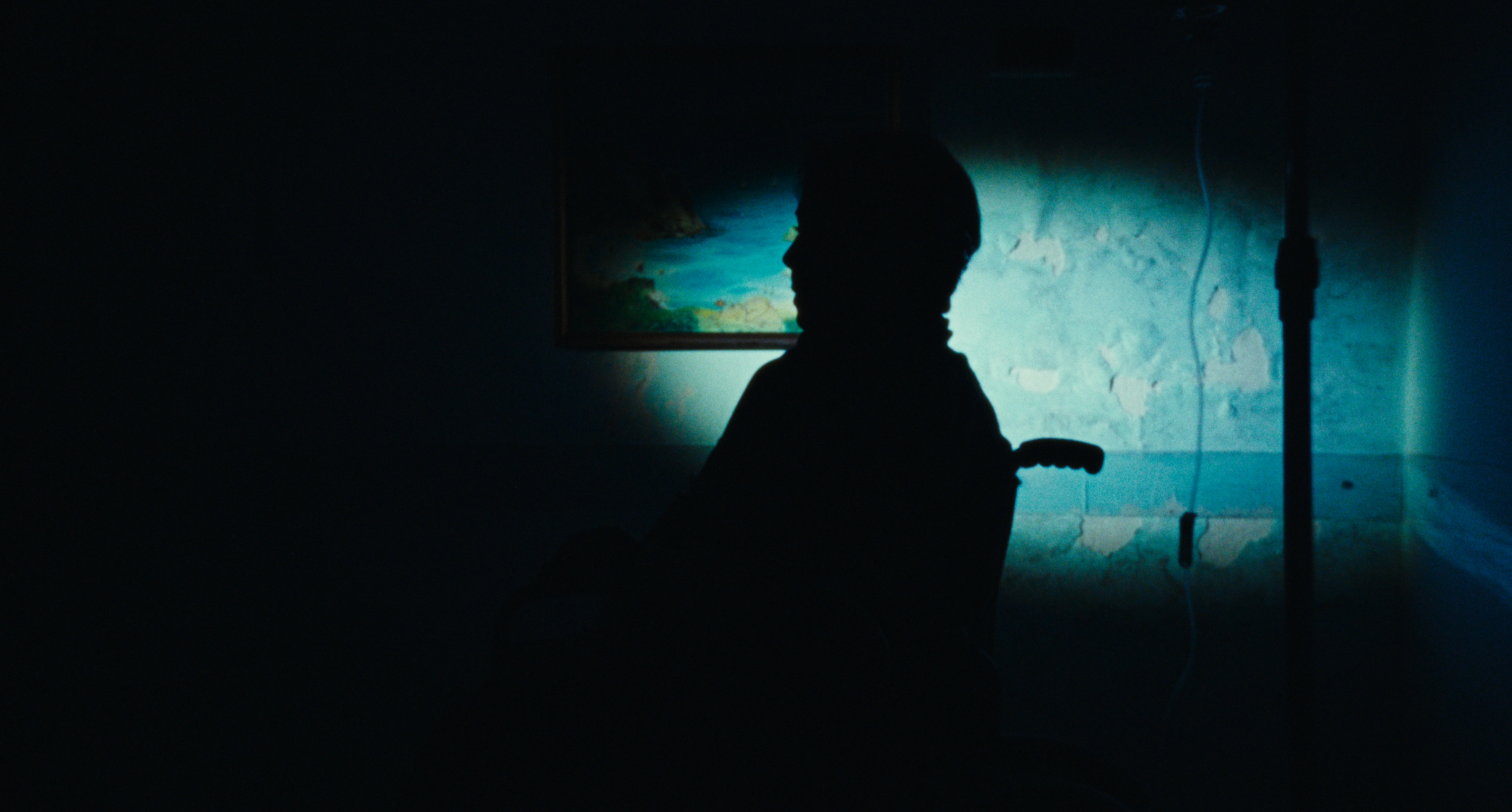 A silhouetted profile against a blue-lit wall