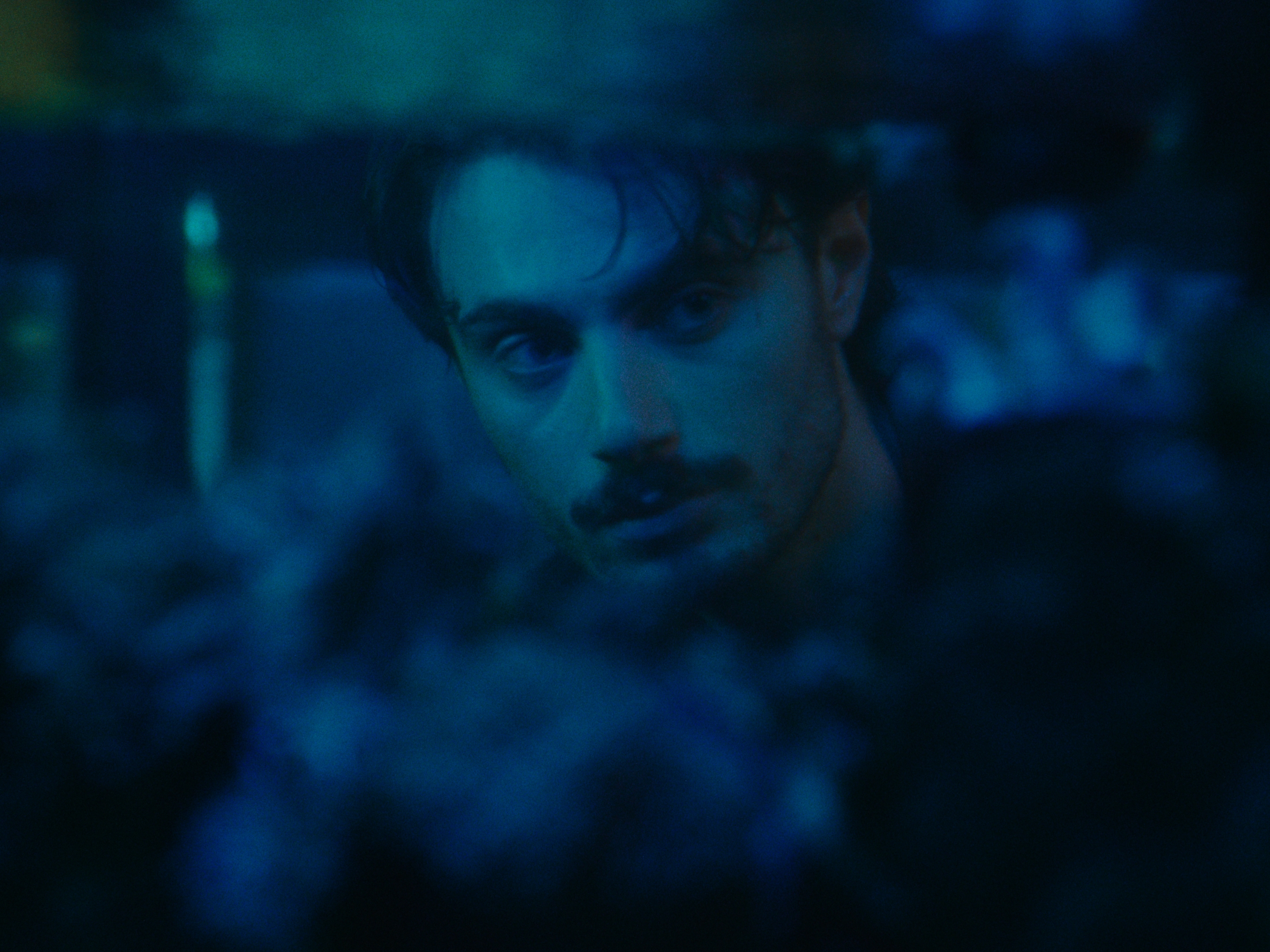 A close-up portrait in blue night light