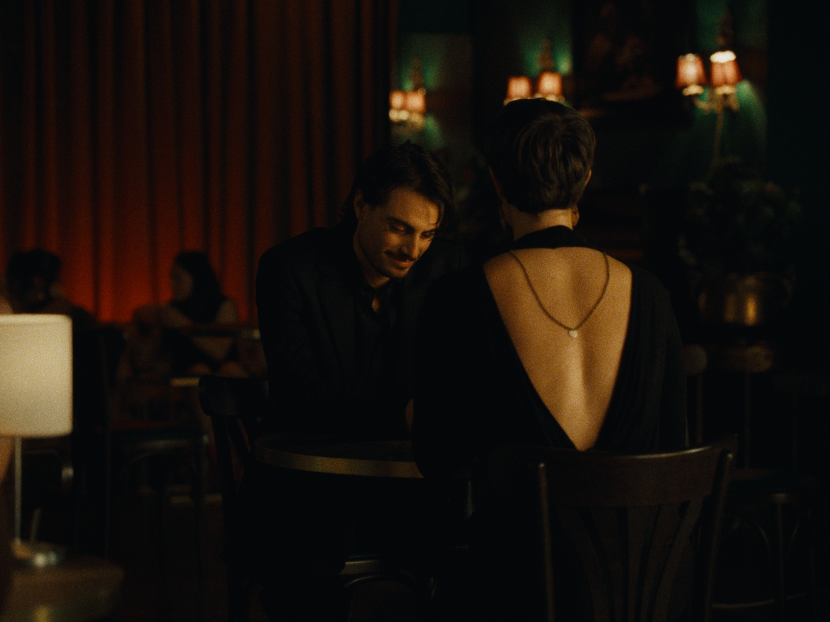 Two people at a table in a warmly lit restaurant