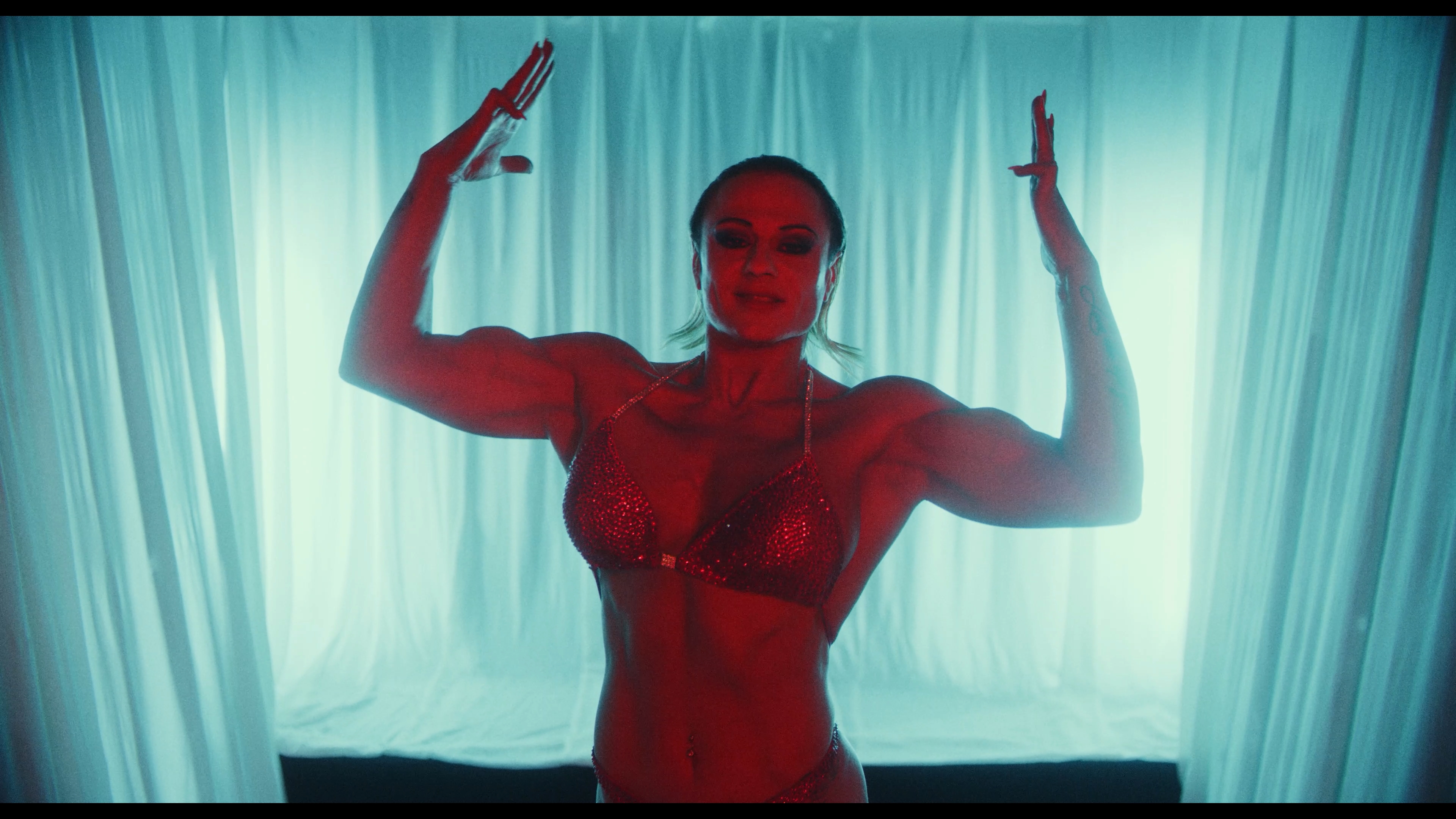A dancer in turquoise and red light