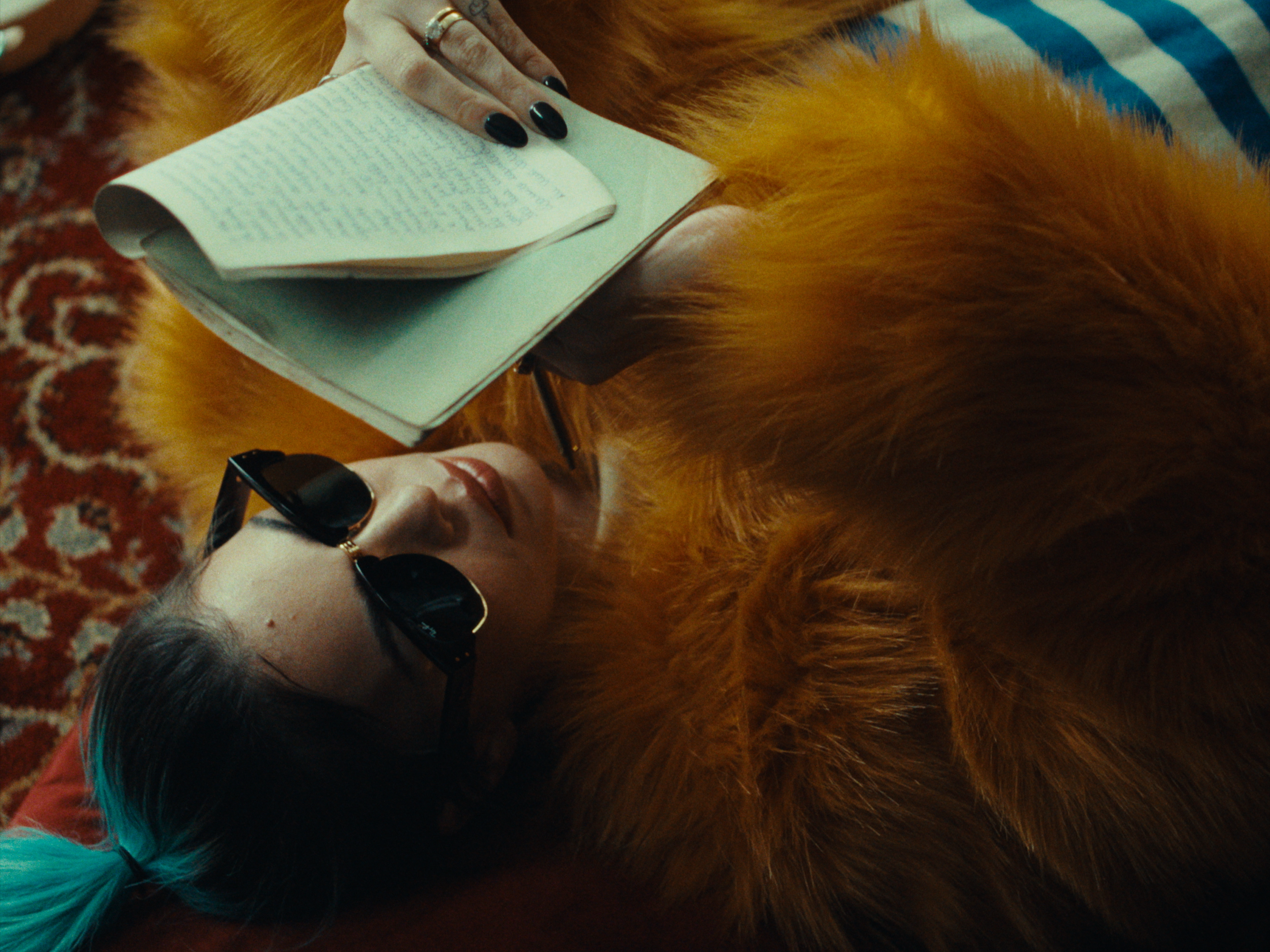 A woman wearing sunglasses and holding an open book