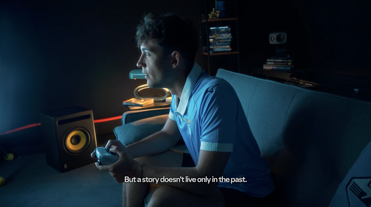 A player with a game controller in a blue-lit room