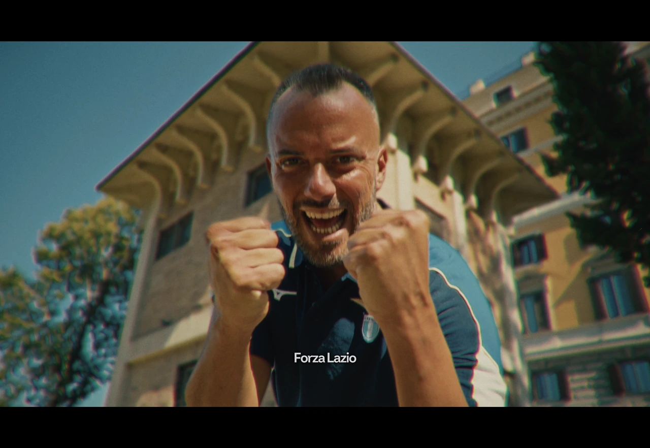 An SS Lazio supporter cheering outside a building