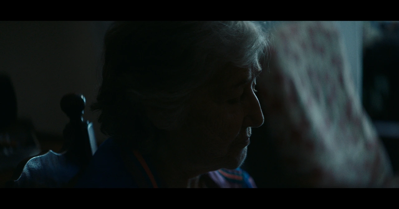 An older man in profile in cool blue window light