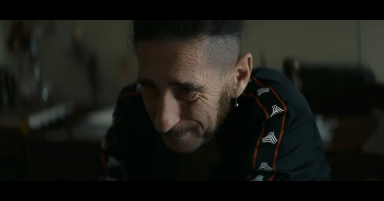 A close-up of a man looking down in soft light