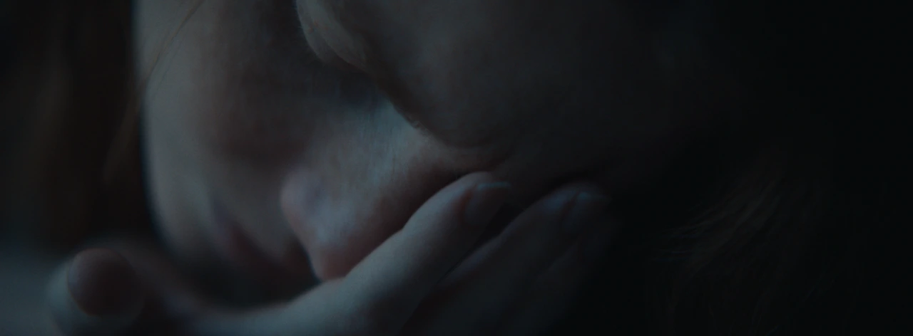 A close-up of a woman resting against her hand