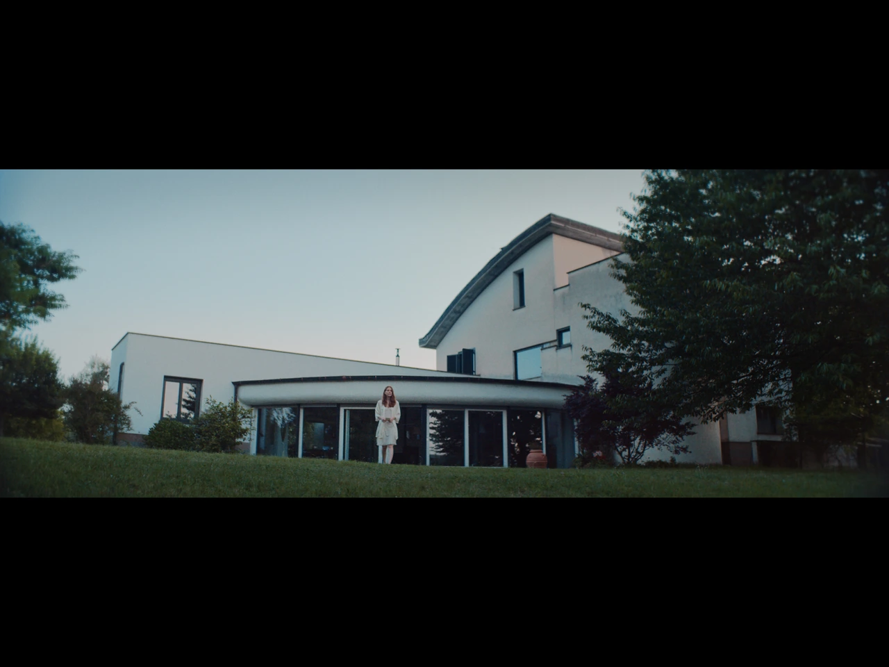 A woman standing outside a modern house