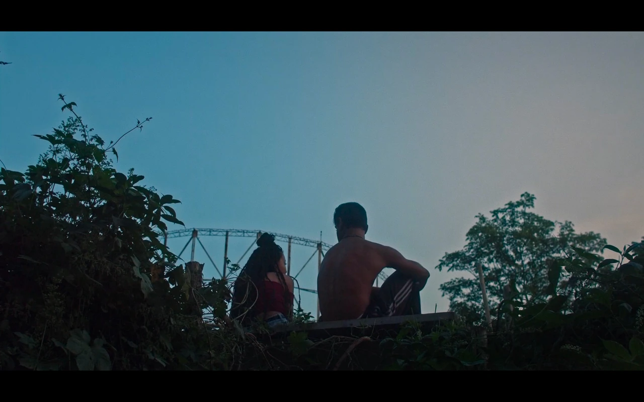 Two people sitting outside against a blue evening sky