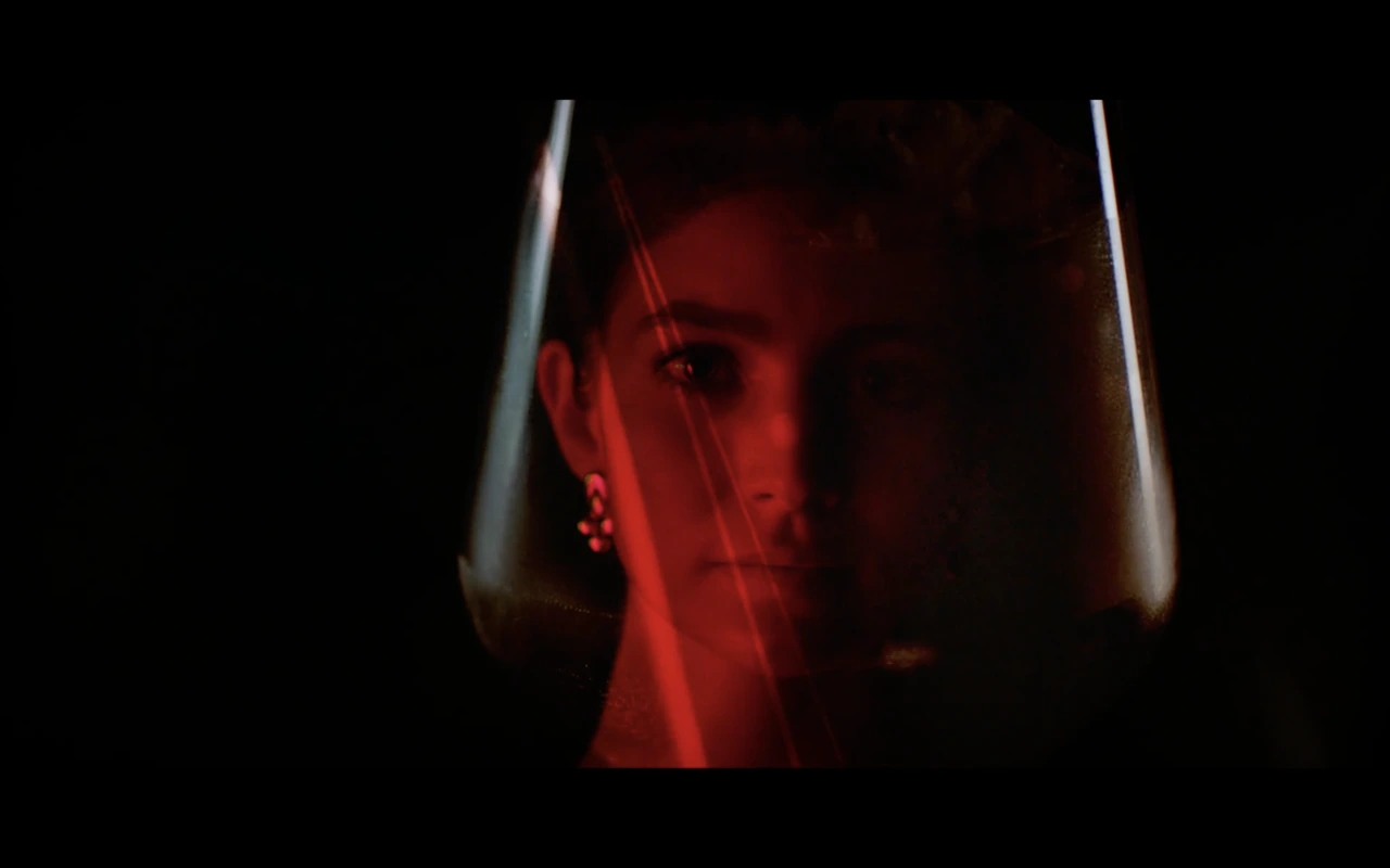 A portrait reflected through a glass in red light