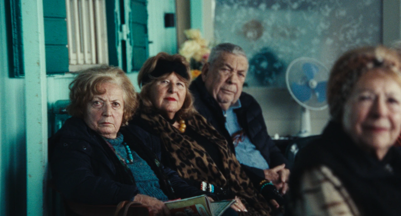Three people seated beside the windows in blue light