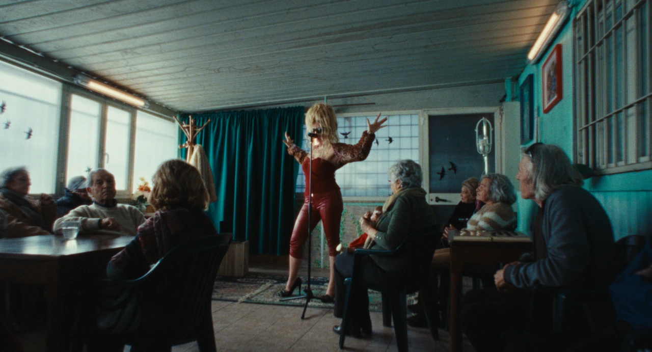 MYSSKETA performing between tables in a blue room