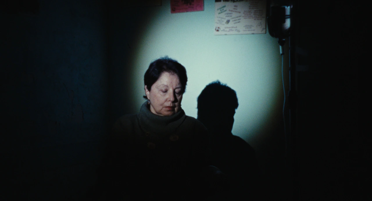 A portrait lit by a spotlight against a blue wall