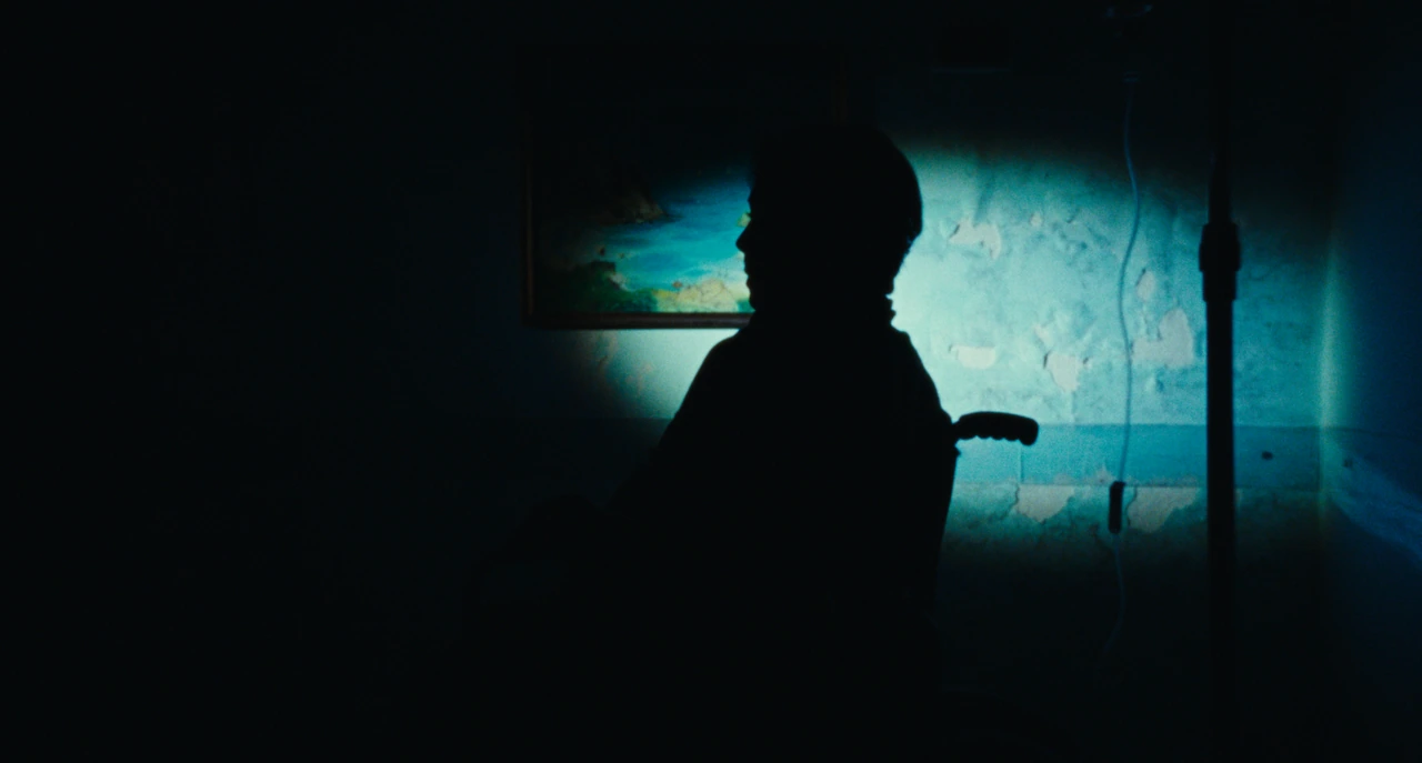A silhouetted profile against a blue-lit wall