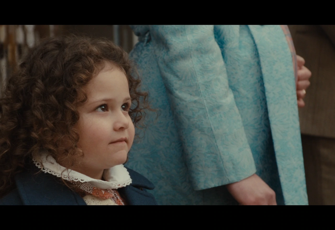 A young girl beside a woman in blue