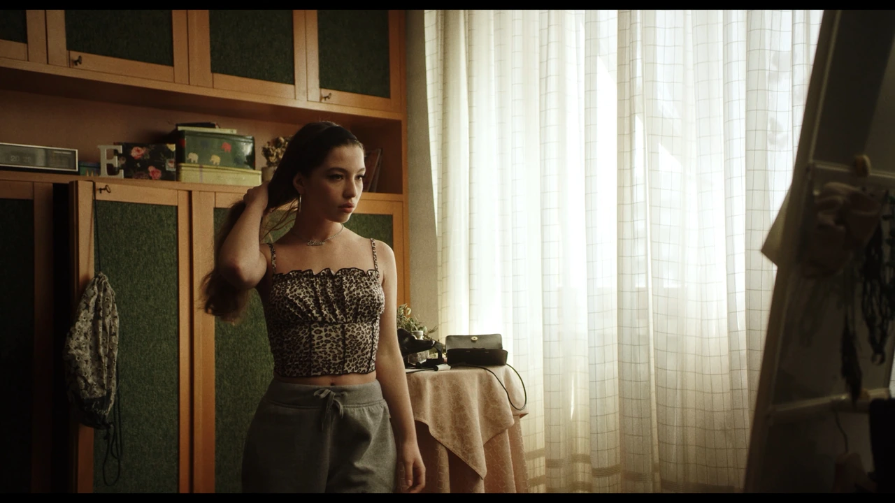 A woman standing beside a sunlit window