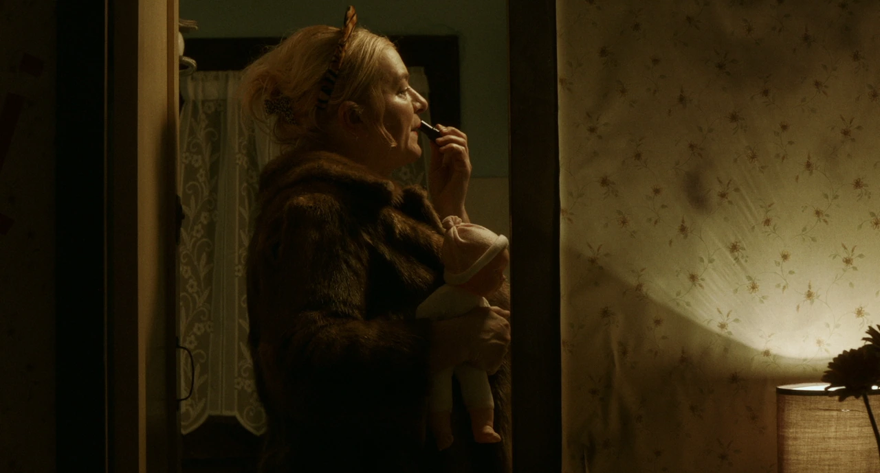 A woman applying lipstick beside a mirror in warm light