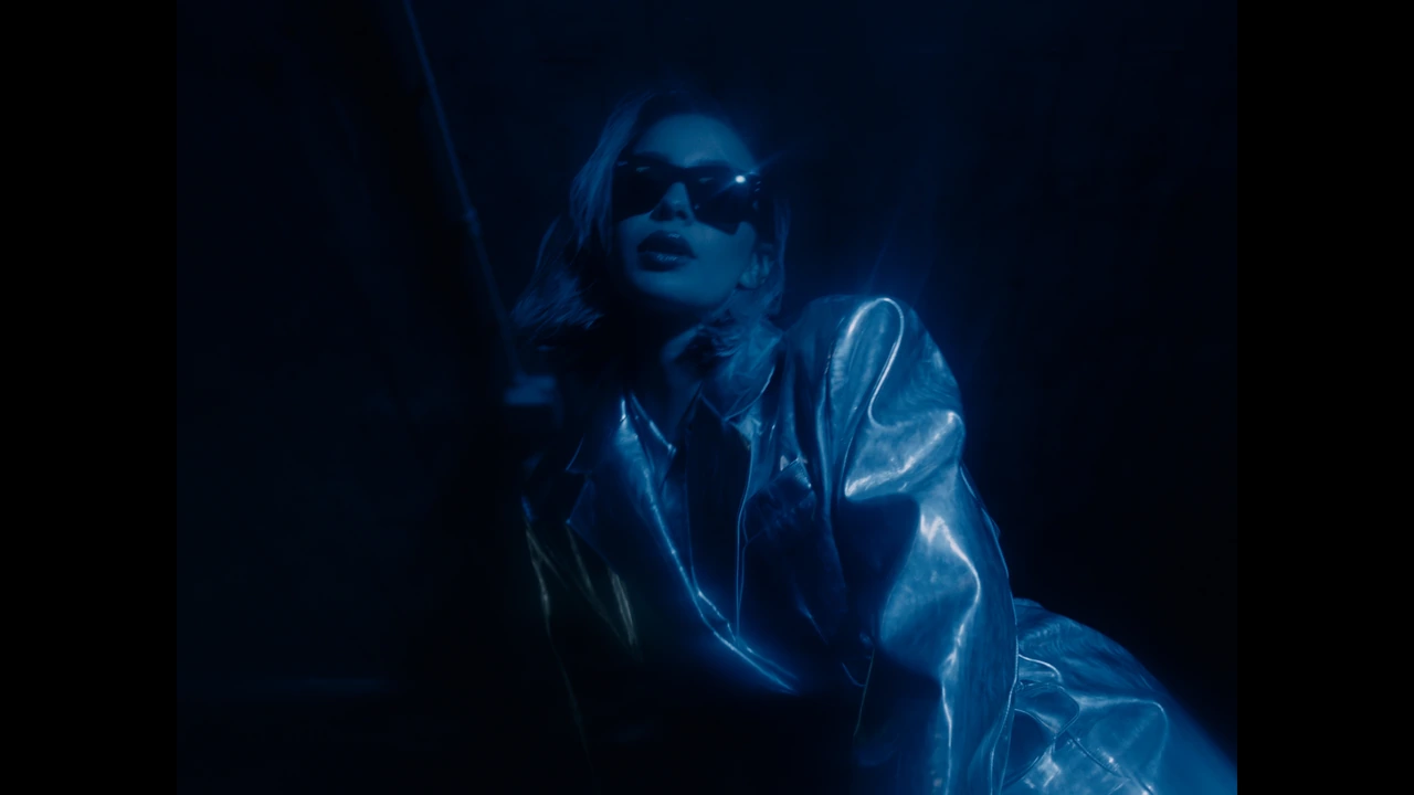 A woman wearing sunglasses in blue light