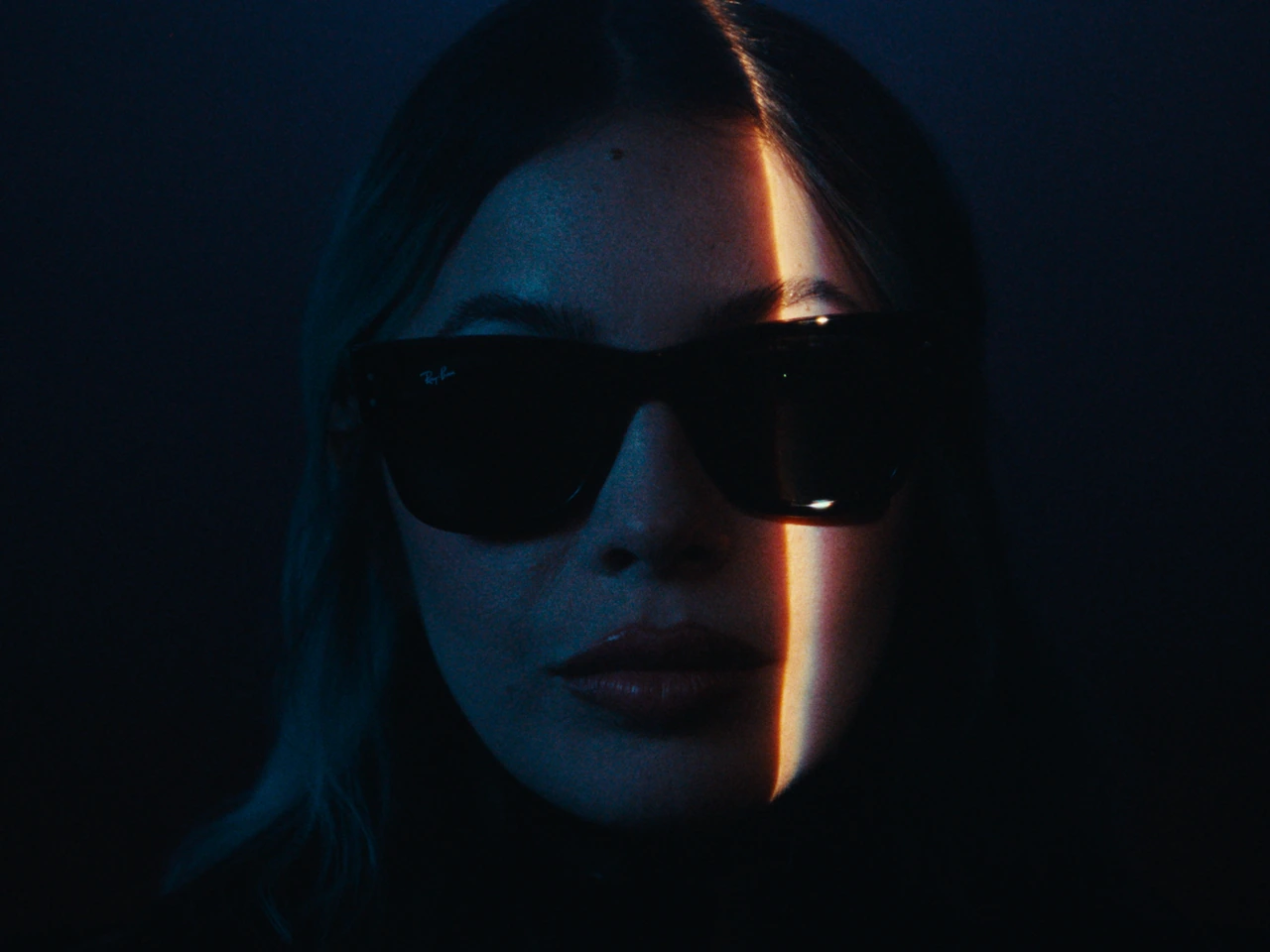 A close-up wearing sunglasses with a narrow band of warm light