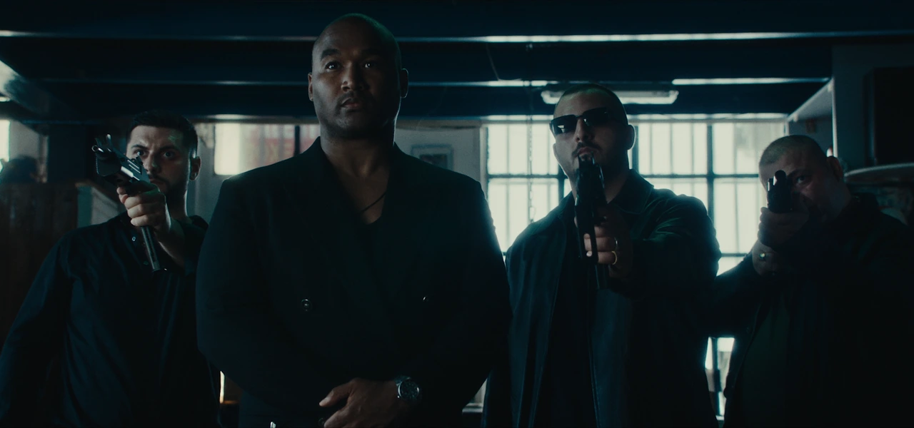 Four men dressed in black in a boxing gym