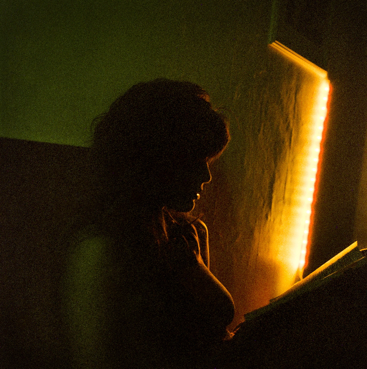 A profile beside a glowing amber light