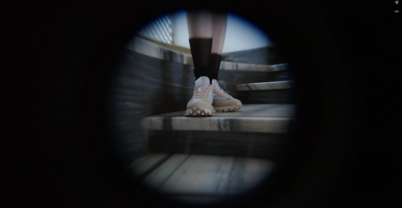 A close-up of pale sneakers on a staircase seen through a circular lens